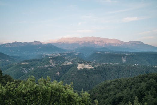 Expansive view of lush green mountains and a clear blue sky during the day.