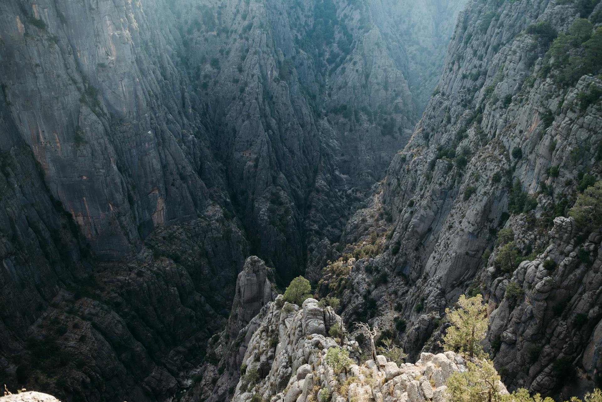 Explore the breathtaking views of a massive rocky canyon with steep cliffs, perfect for adventure seekers.