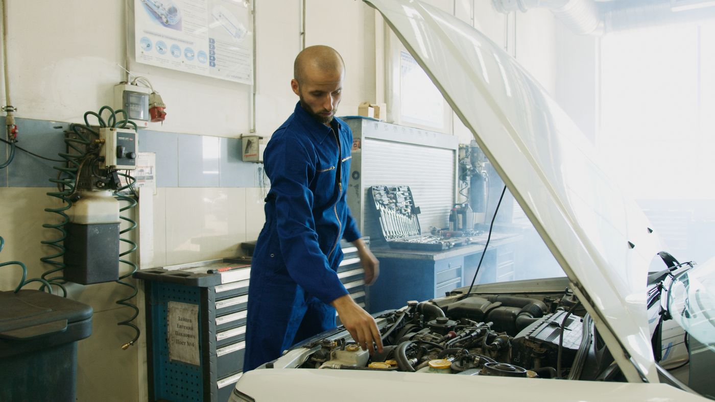 Mechanic inspecting a vehicle engine in the workshop