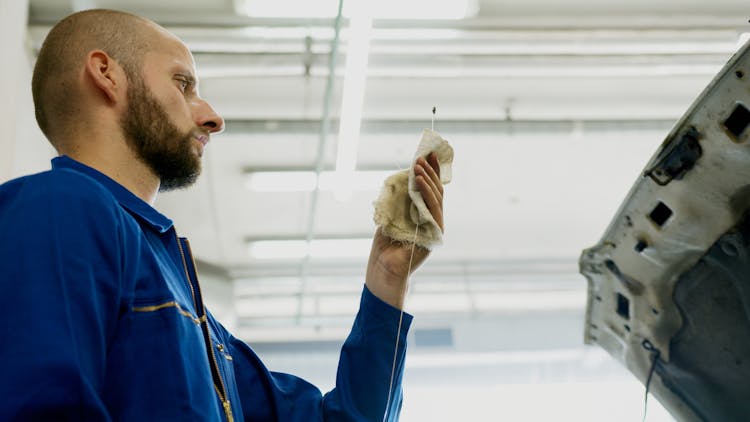 Man Looking At A Dipstick