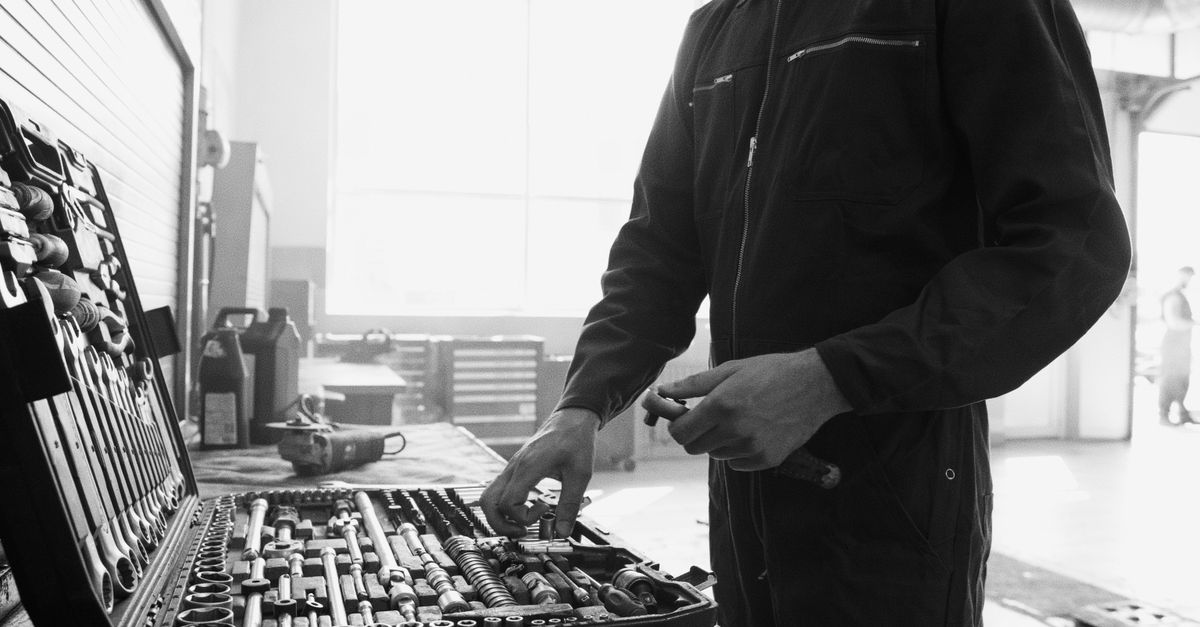 Auszubildender Kfz-Mechatroniker bei der praktischen Ausbildung in der Werkstatt