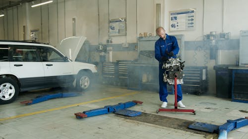 Free Man in Blue Overall Fixing Engine Stock Photo