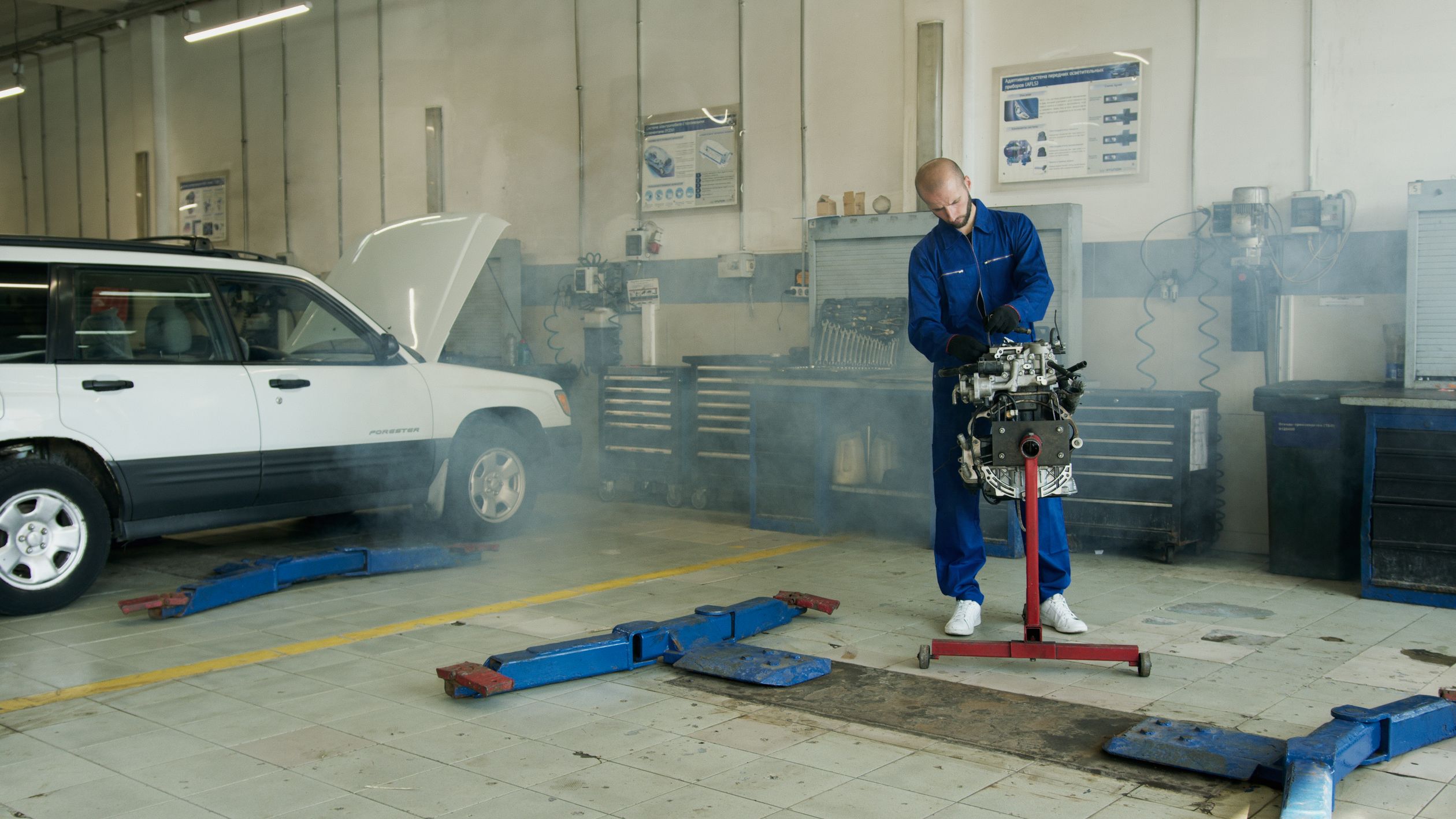 Man in Blue Overall Fixing Engine · Free Stock Photo
