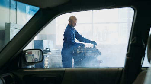 Free Man in Blue Overall Fixing Motor Stock Photo