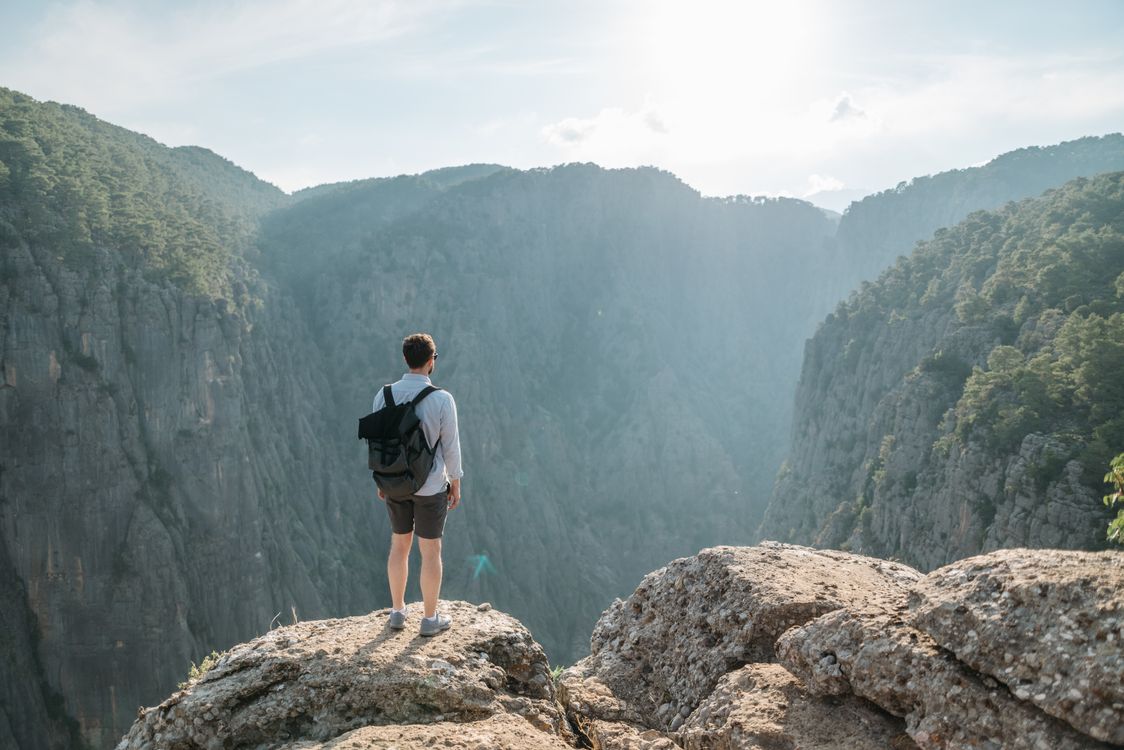 Man with Backpack Standing on the Edge of the Cliff · Free Stock Photo