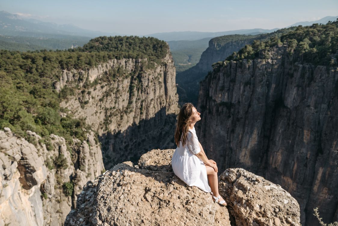 Woman in White Dress Sitting on a Cliff · Free Stock Photo
