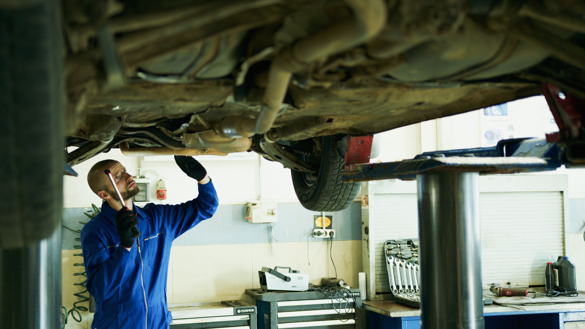 Man Under the Car Fixing the Engine