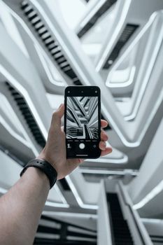 A contemporary building's geometric design captured through a smartphone, showcasing innovative architecture.