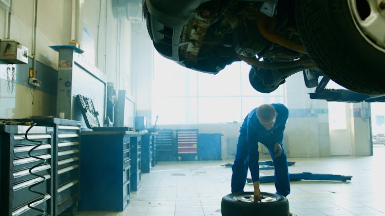 A Man Holding A Wheel Tire