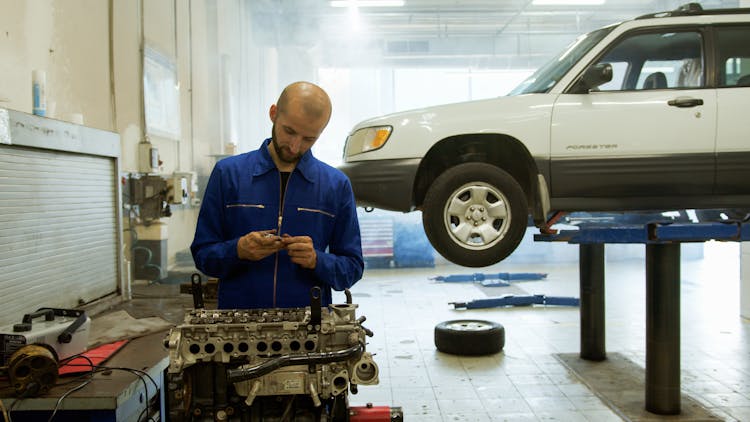 A Man Repairing A Vehicle Motor