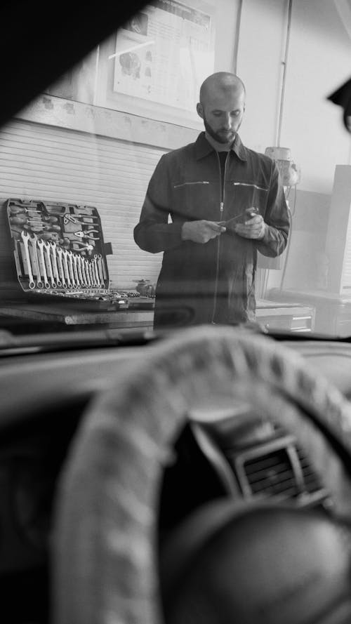 Black and White Photo of a Mechanic Holding a Wrench