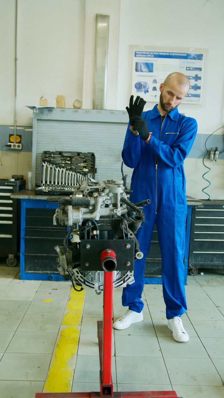 FixLab mechanic in blue overalls preparing for engine work