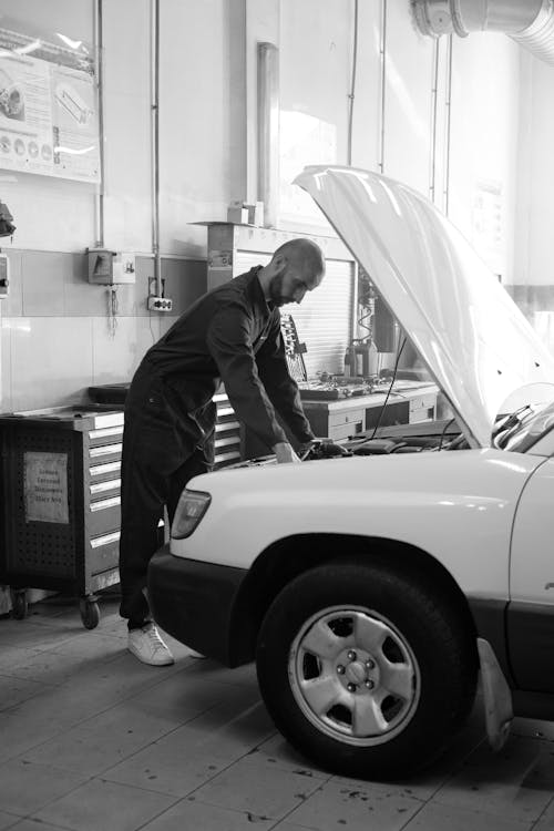 A Man Repairing a Car in a Workshop