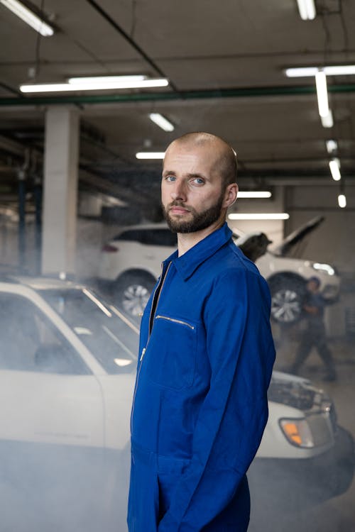 Man In Blue Coverall Standing Near A Car
