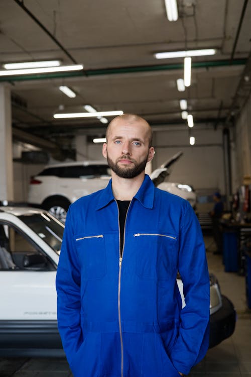 An Man in Blue Coveralls at an Auto Repair Shop