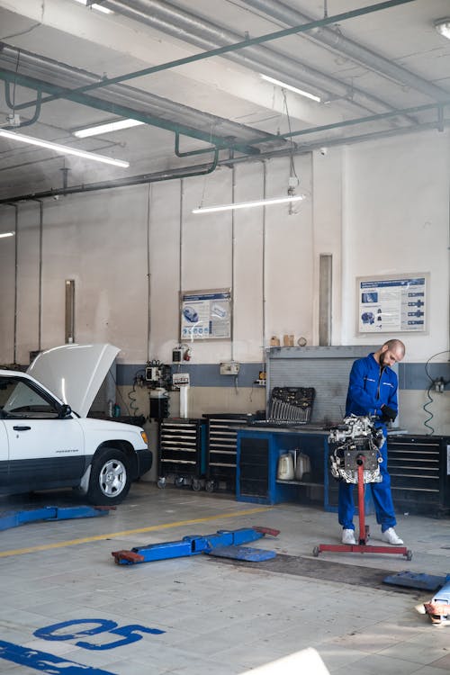 A Mechanic Working on an Engine in an Auto Repair Shop