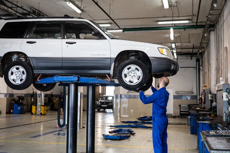 A Mechanic Inspecting A Vehicle