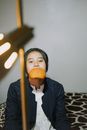 Woman in Black Blazer Holding Orange Fruit