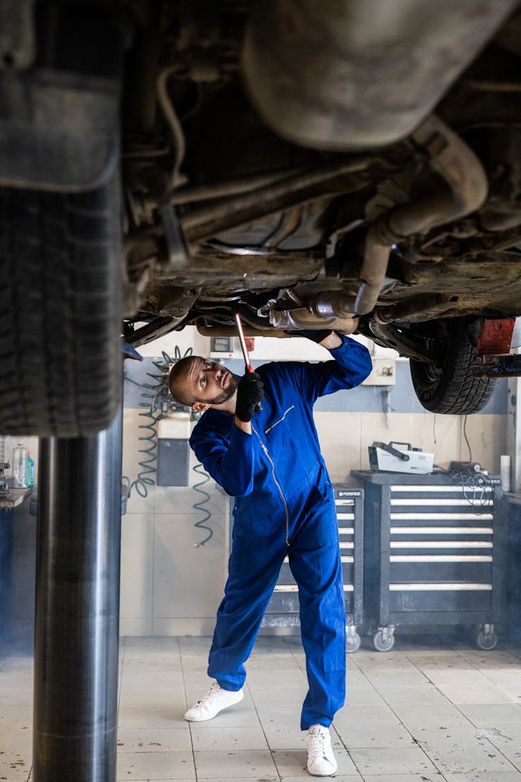 Woman In Blue Coverall Fixing The Car 