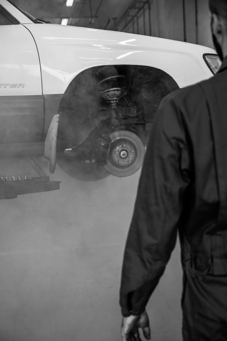 Person Standing Near A Car On A Lift