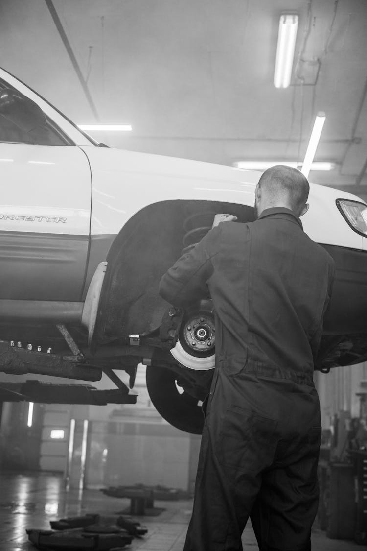 Man Fixing The Brake Of A Car