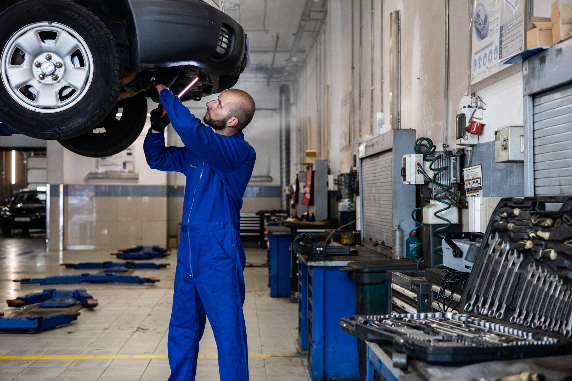 OWN Garage mechanic servicing a car on a lift