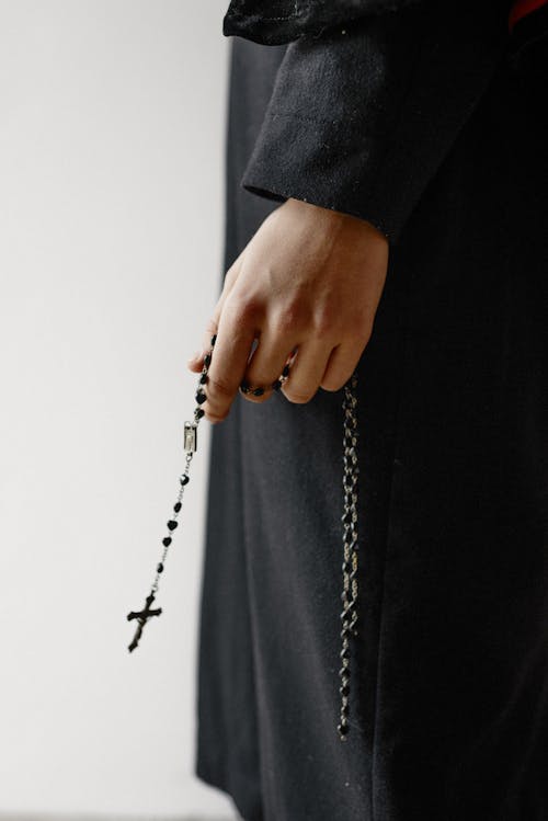 Person Holding A Black Rosary