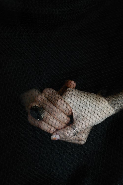 Free A portrait of hands clasped under a black veil, symbolizing elegance and mourning. Stock Photo