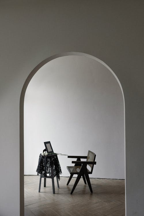 An Archway Towards a Room with Table and Chair 