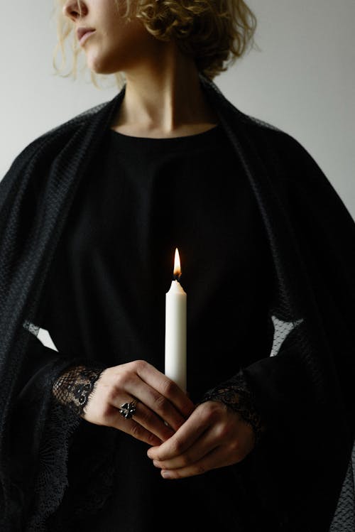 Woman in Black Outfit Holding Lighted Candle 