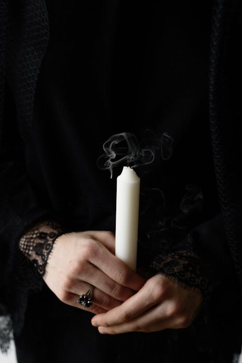 Close-up of a Person Holding a White Candle