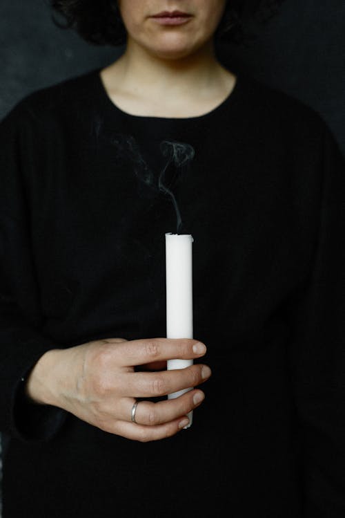 Person in Black Dress Holding Candle 