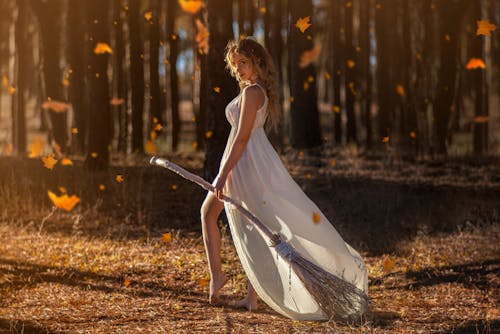 A White Witch Holding a Broomstick