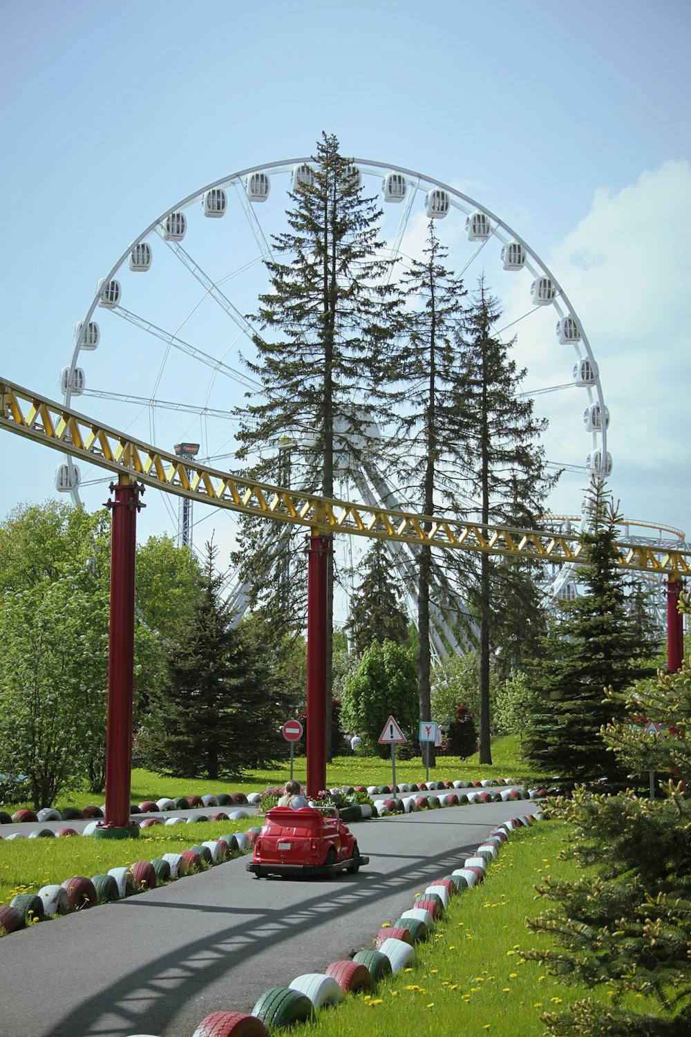 Theme Park Car Ride and a Ferris Wheel in the Background · Free Stock Photo