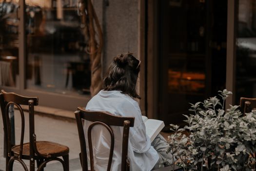Backside of a Seated Woman Reading a Book