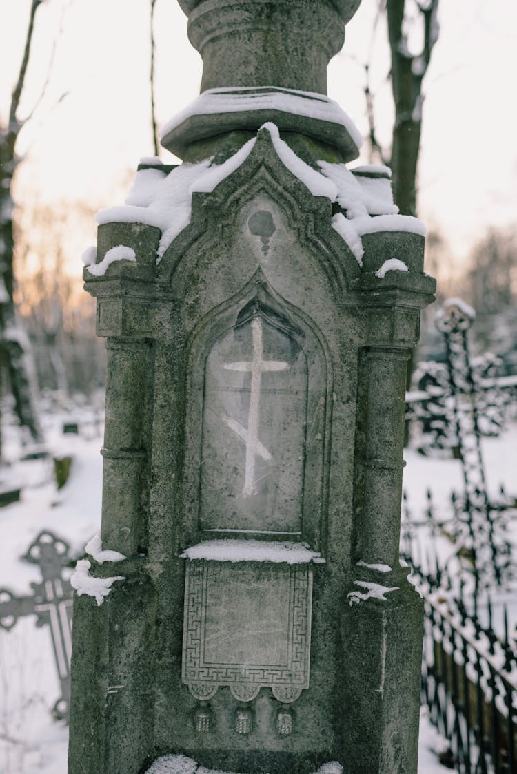 A Concrete Tombstone Covered With Snow