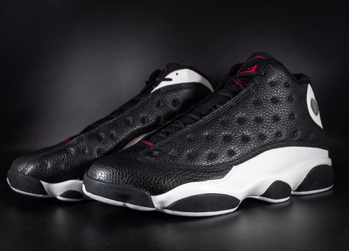 Free Close-up shot of stylish black and white sneakers on a dark background, highlighting their sleek design. Stock Photo