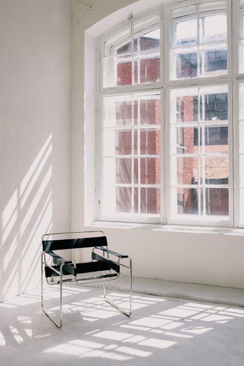 Metal Chair Beside Glass Windows 