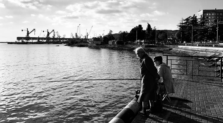 An Elderly Couple Fishing On The Dock