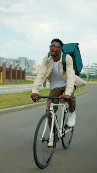 African American cyclist with backpack riding bike on urban road. Outdoor active lifestyle.