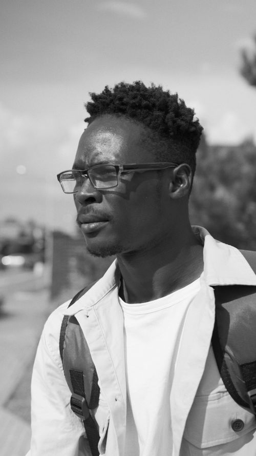 Free Black and white portrait of a young African American man wearing glasses outdoors. Stock Photo