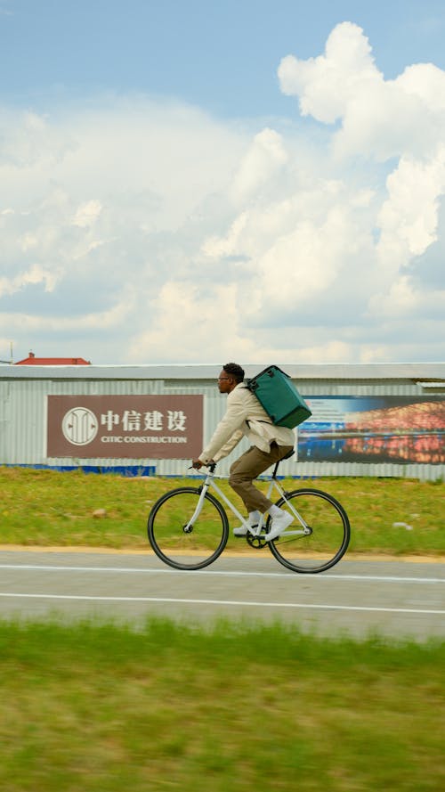 Man Carrying a Delivery Bag Riding a Bicycle