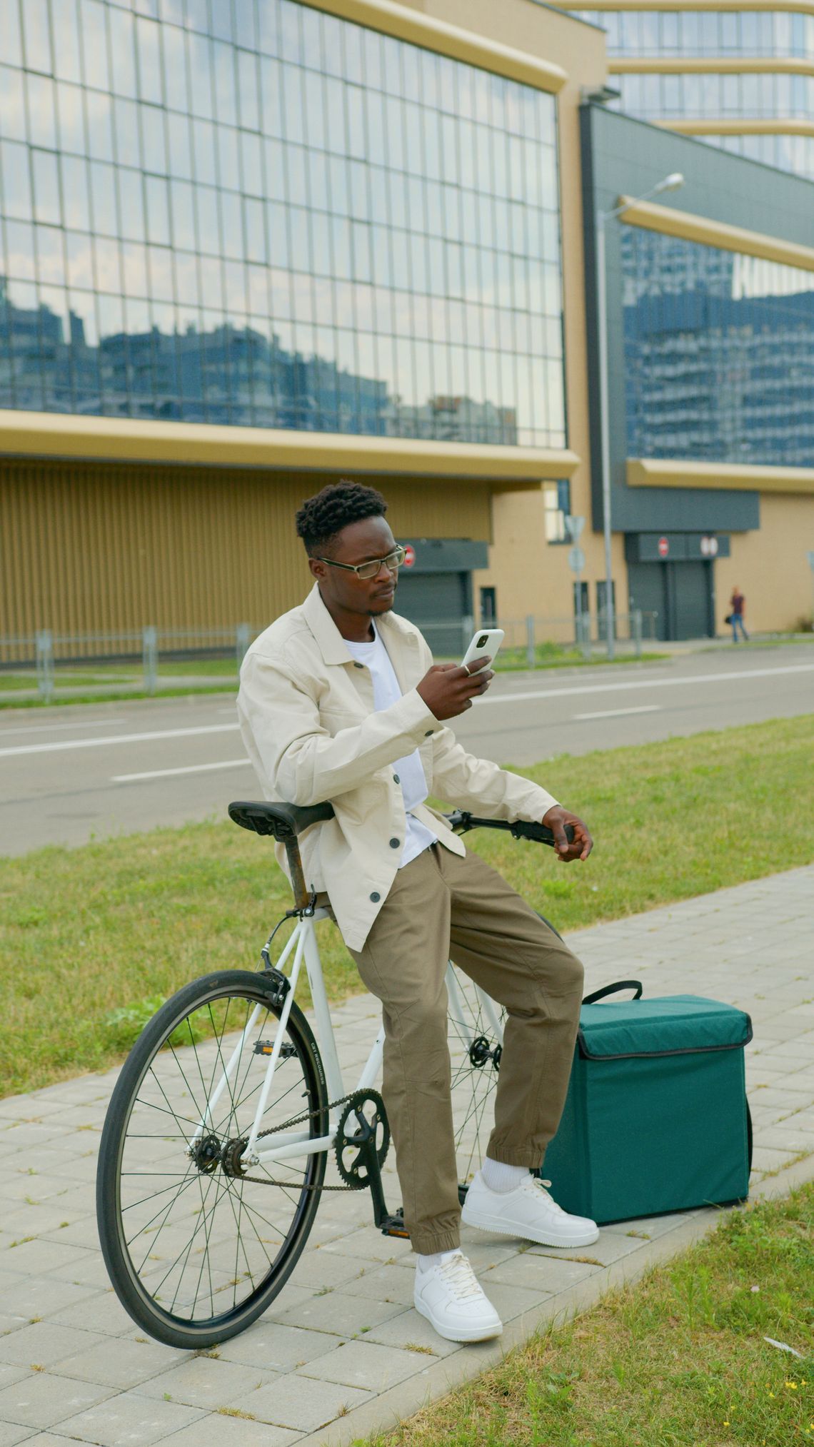 Cyclist using a smartphone while seated on a bicycle in an urban setting