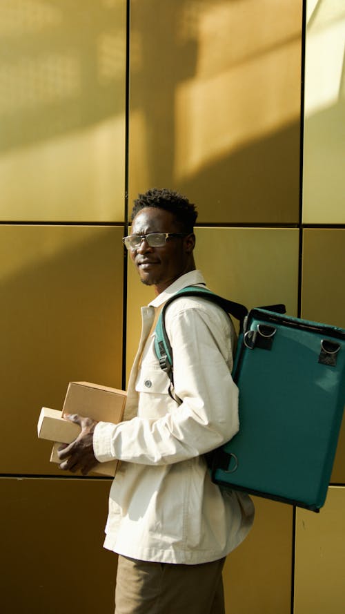 Gratis stockfoto met Afro-Amerikaanse man, bezorgtas, dozen
