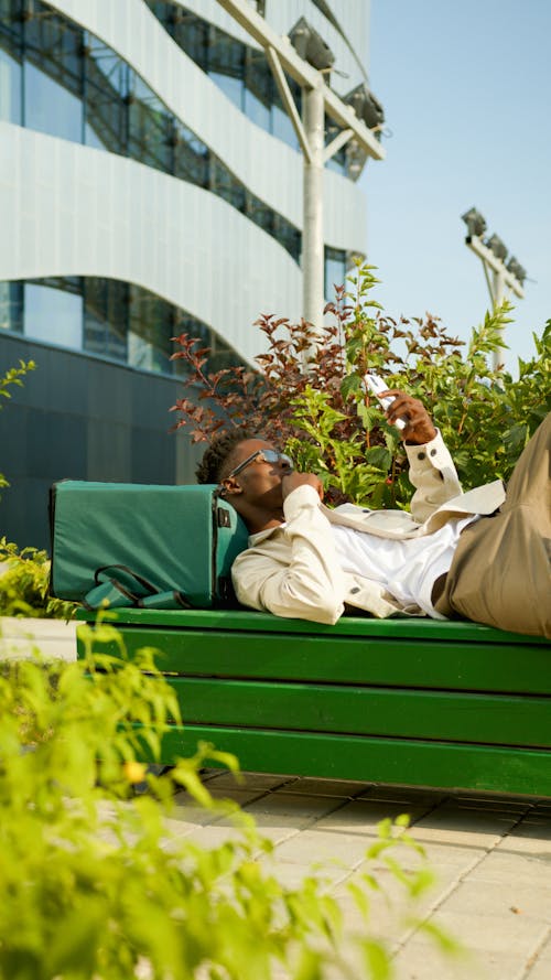 Deliveryman Resting on a Green Bench