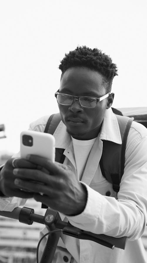 A Grayscale of a Man Using a Smartphone