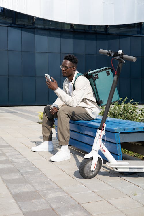 A Man Sitting on a Bench While Using His Phone