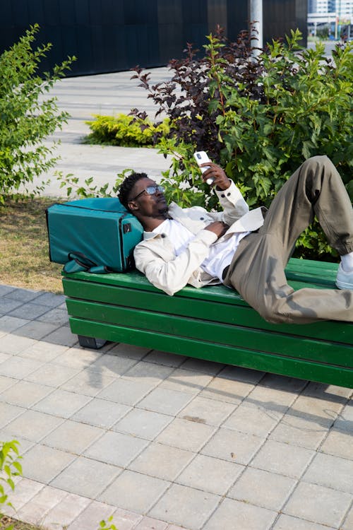 A Man Lying Down on a Bench