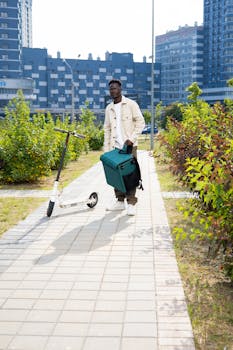 Young man delivering in the city with an electric scooter and thermal bag.