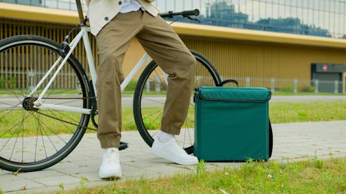 A Close-Up Shot of a Person Leaning on a Bicycle